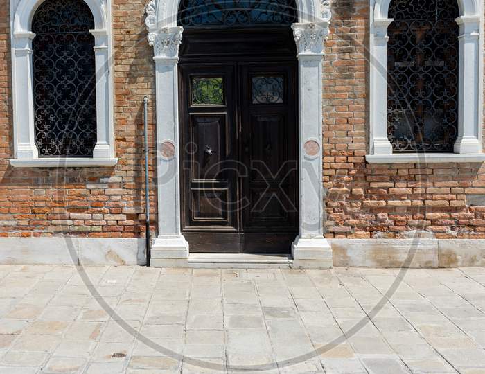 Italy, Venice, A Stone Building That Has A Bench In Front Of A Brick Wall