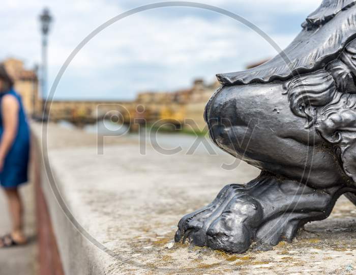 The Base Of The Lamp Post Near Ponte Vecchio Over The Arno River In Florence, Italy