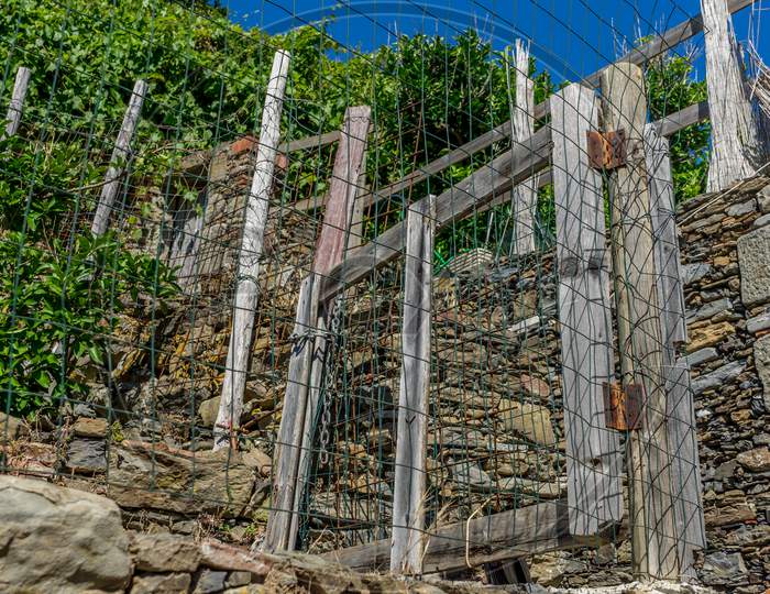 Italy, Cinque Terre, Vernazza, A Close Up Of A Rock Next To A Fence