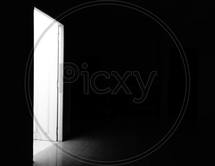 Heaven's Bright/ White door in a dark room with black background