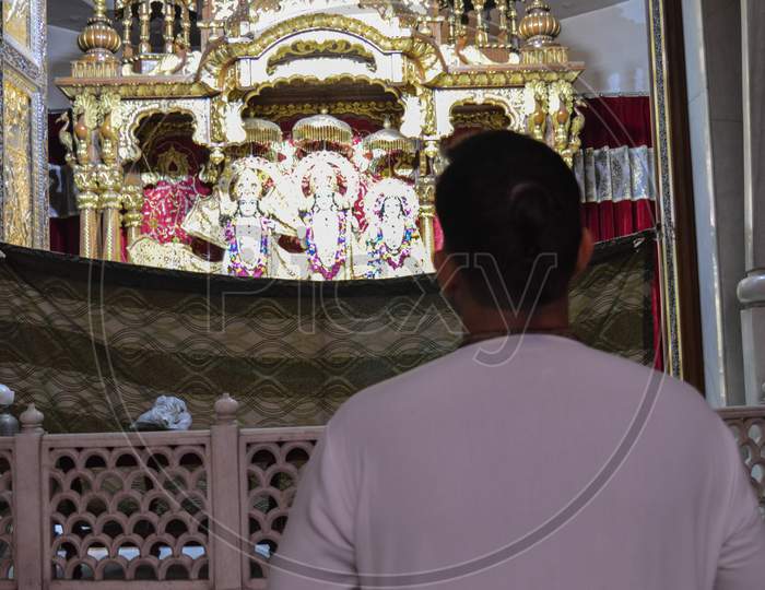 A Man Is Looking At God Lord Krishna And Praying For Good Wealth And Health On The Indian Festival Of Lord Krishna Birth Ceremony( Janmastami) At Iskcon Temple New Delhi, India.