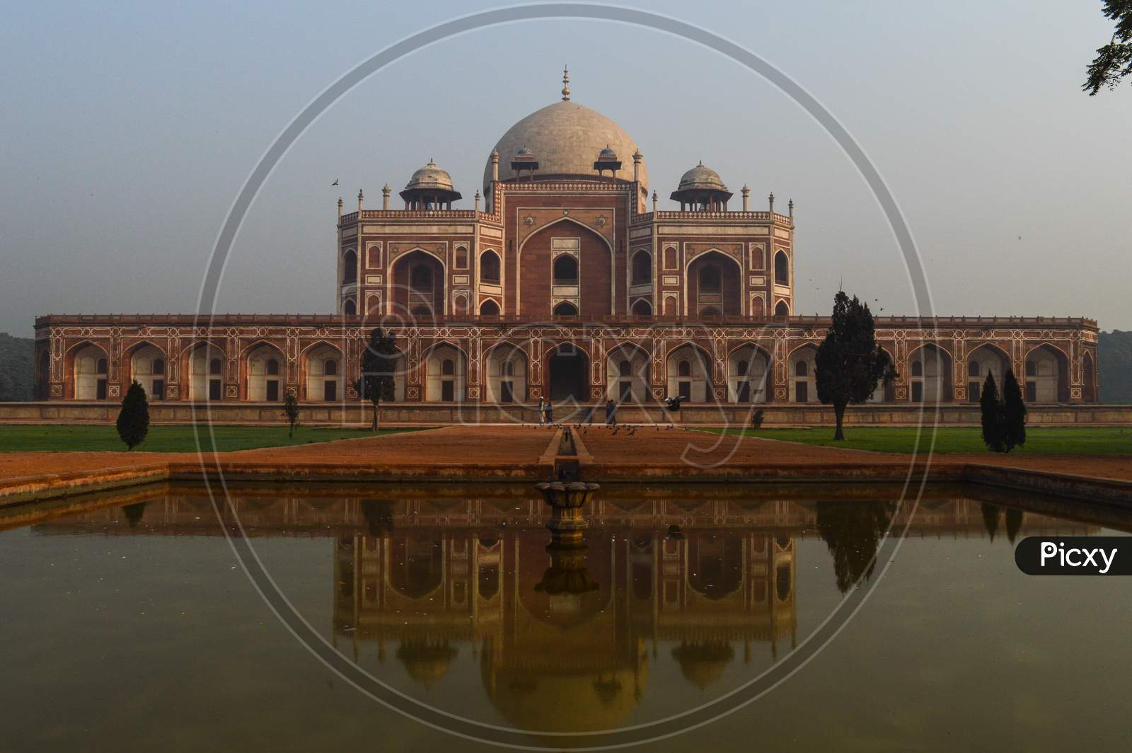 A Reflection In Water And Mesmerizing View Of Humayun Tomb Memorial From The Main Gate,Entrance At Winter Foggy Morning.