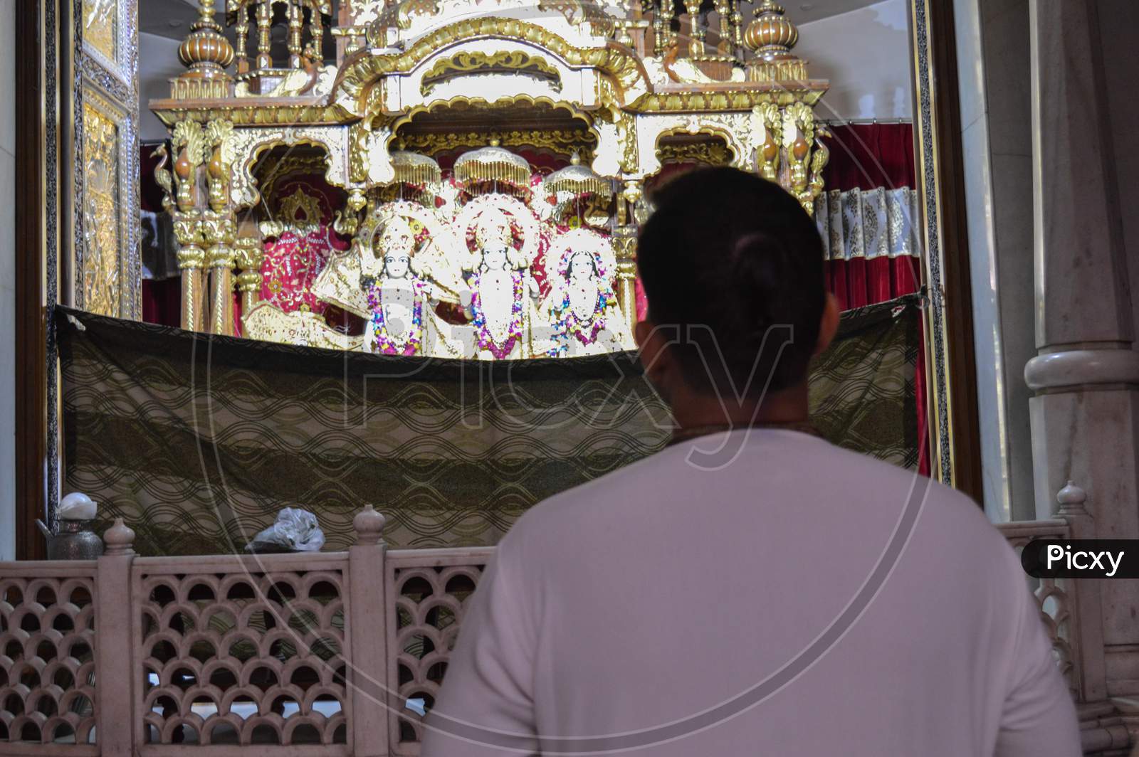 A Man Is Looking At God Lord Krishna And Praying For Good Wealth And Health On The Indian Festival Of Lord Krishna Birth Ceremony( Janmastami) At Iskcon Temple New Delhi, India.