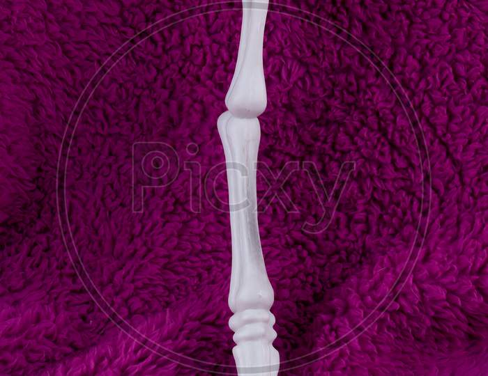 Leg Bone Standing Against Purple Background. Concept For Halloween extra