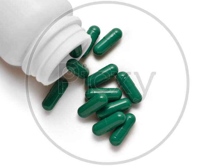 Green Capsule Pills And Bottle Isolated On White Background