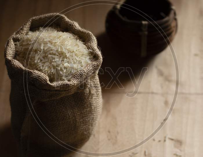Heap Of Rice Grain In A Jute Bag With Measuring Bowl