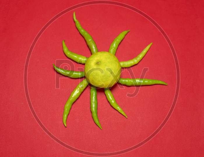 Yellow Lemon And Green Chillies On Red Background