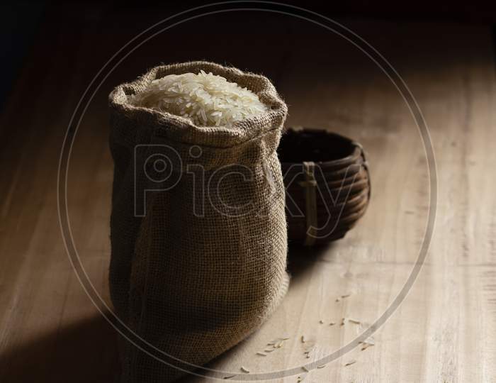 Heap Of Rice Grain In A Jute Bag With Measuring Bowl