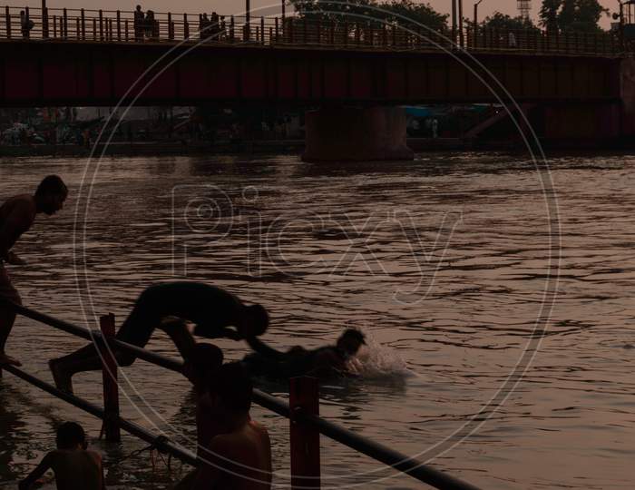 Many Boys Going To Jump Into Ganga River For Relief Of Heat In Summer At Sunrise At Haridwar Bridge Temple Sky.