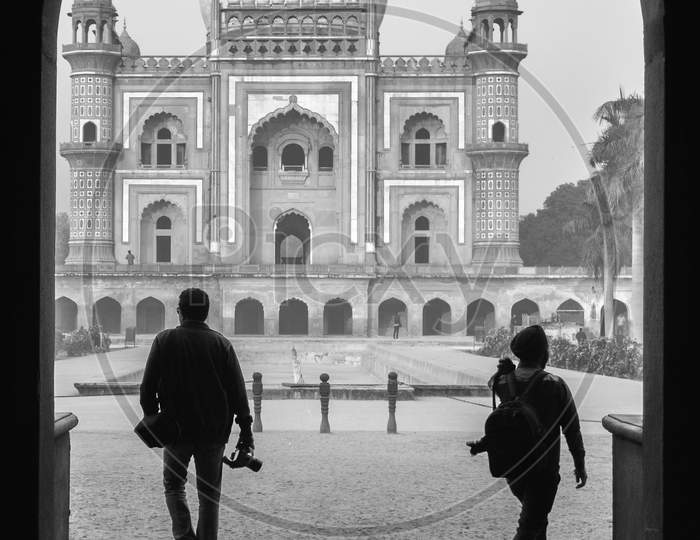 Two Photography Student Walking With Camera Trough The Main Gate,Entrance Of Safdarjung Tomb Memorial At Winter Morning Black And White Silhouette.