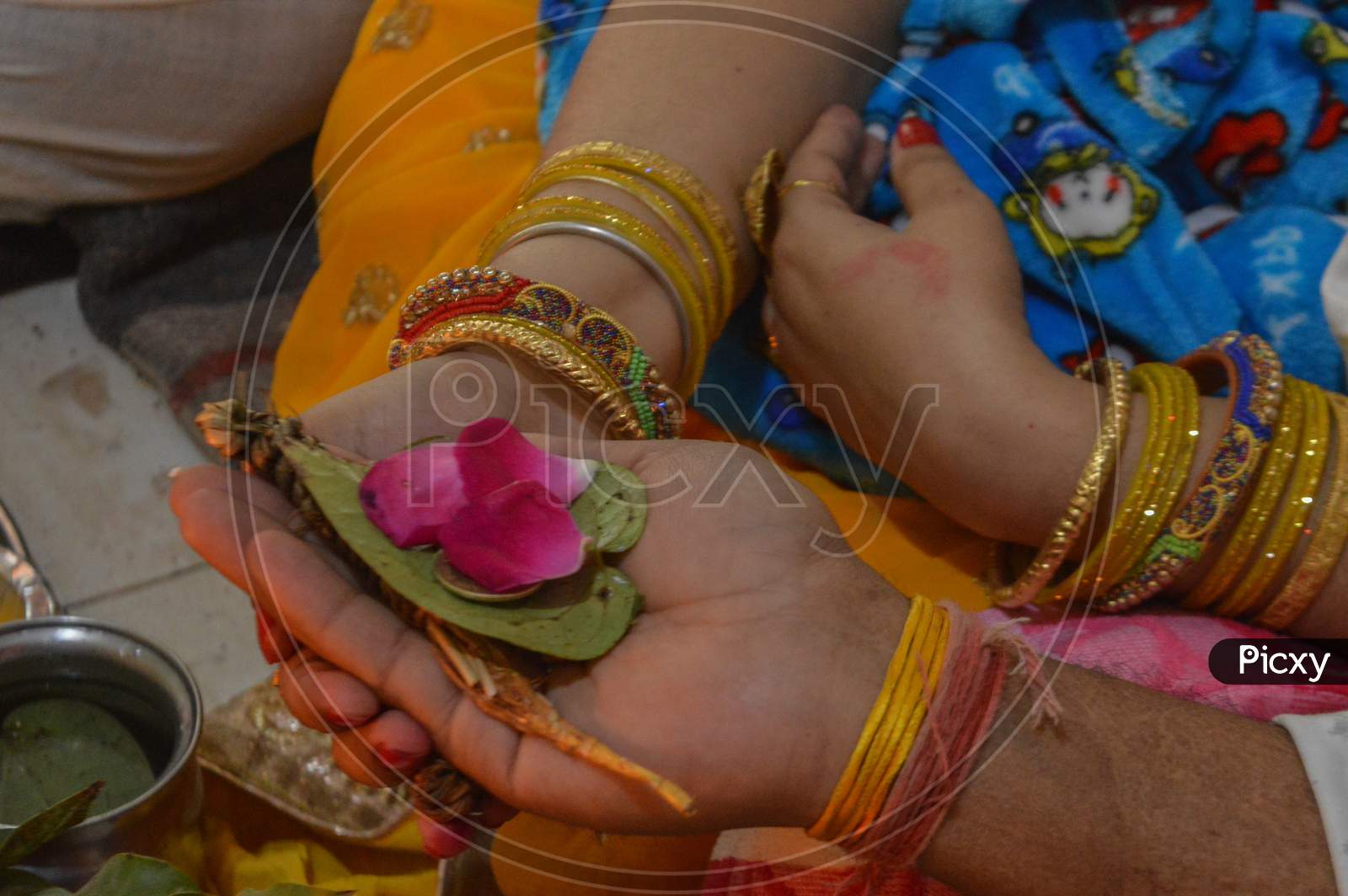 A Indian Couple Holding Each Others Hand And Carrying Betel Plant Leaf And Rose For Worship Of Indian God.