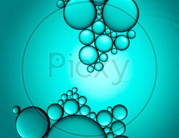 Portrait Of Colorful Oil Drops On A Cyan Background Water Surface
