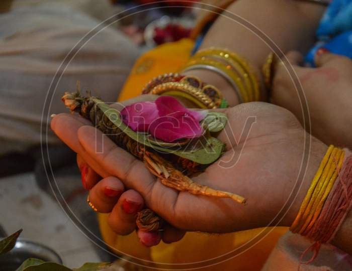 A Indian Couple Holding Each Others Hand And Carrying Betel Plant Leaf And Rose For Worship Of Indian God.