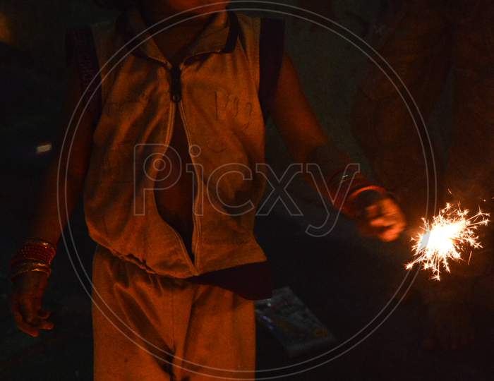 Indian Boy Plying With Fire Cracker With Rose And Candle On Indian Festival Diwali Deepawali With Fire Isolated On Table