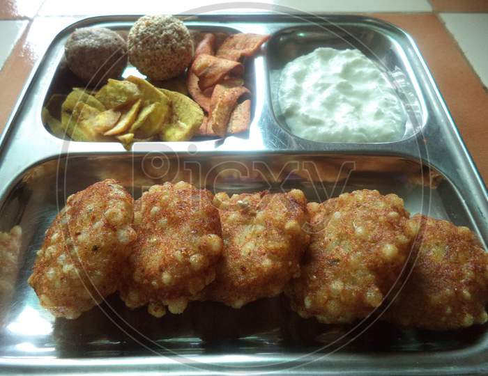 plate for fast including shabudana vada banana chips and curd