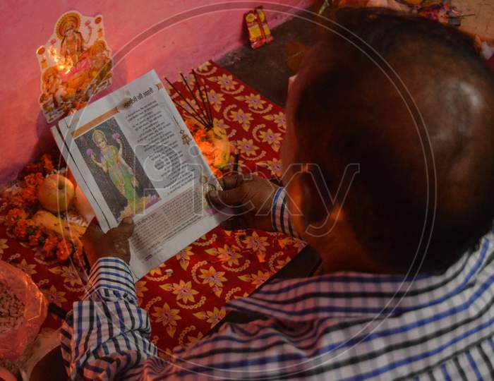 Indian Man Who Is Doing Prayer With Book, Rose And Candle On Indian Festival Diwali Deepawali With Fire Isolated On Table