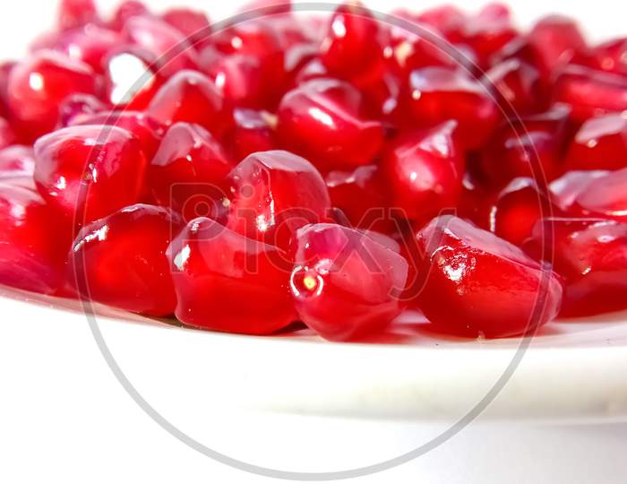 Red pomegranate seeds in isolated white background