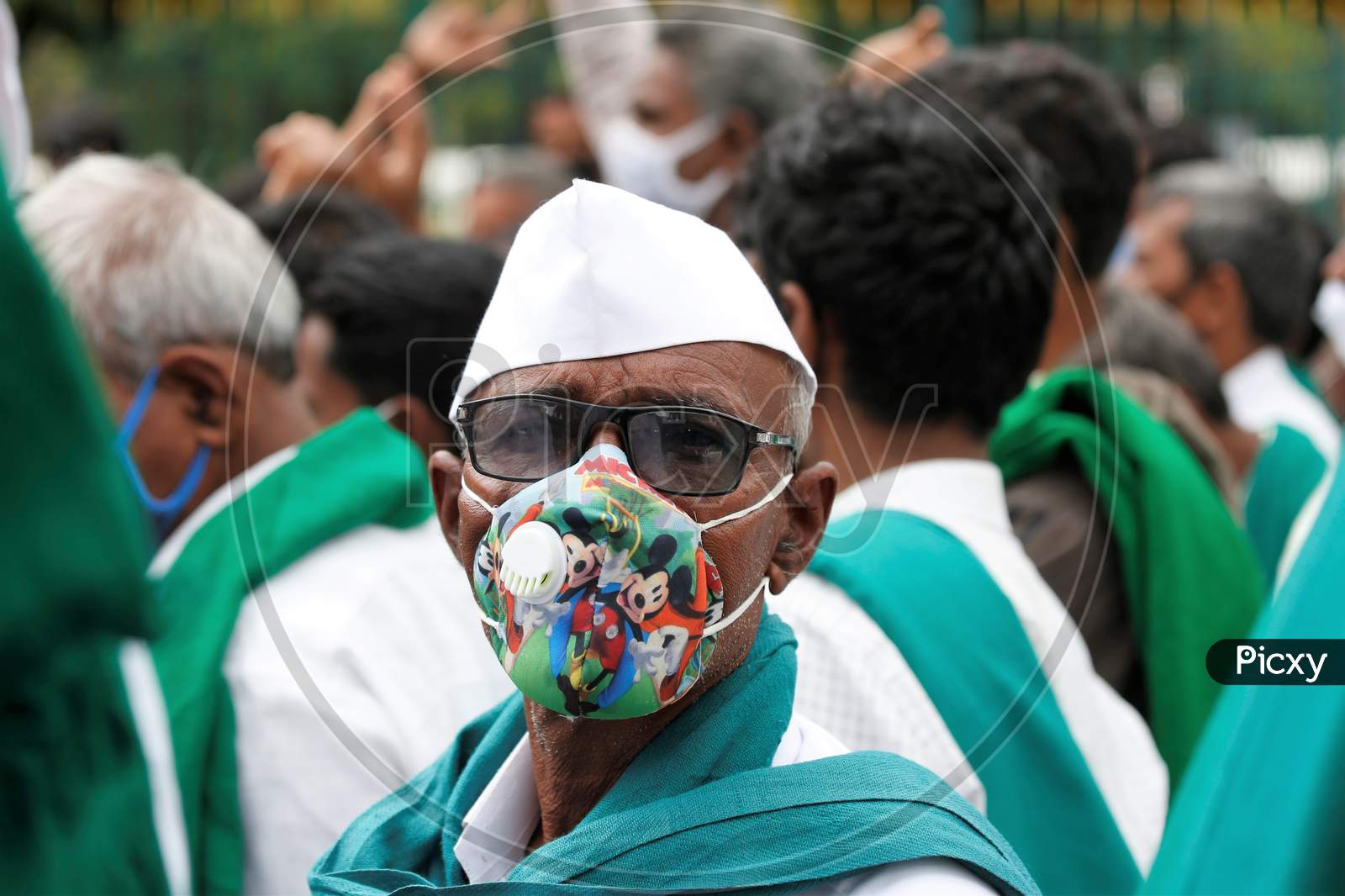A farmer wears a Mickey Mouse mask to protect from the novel coronavirus during a protest against the passage of two controversial farm bills by the country’s parliament in Bangalore, India.