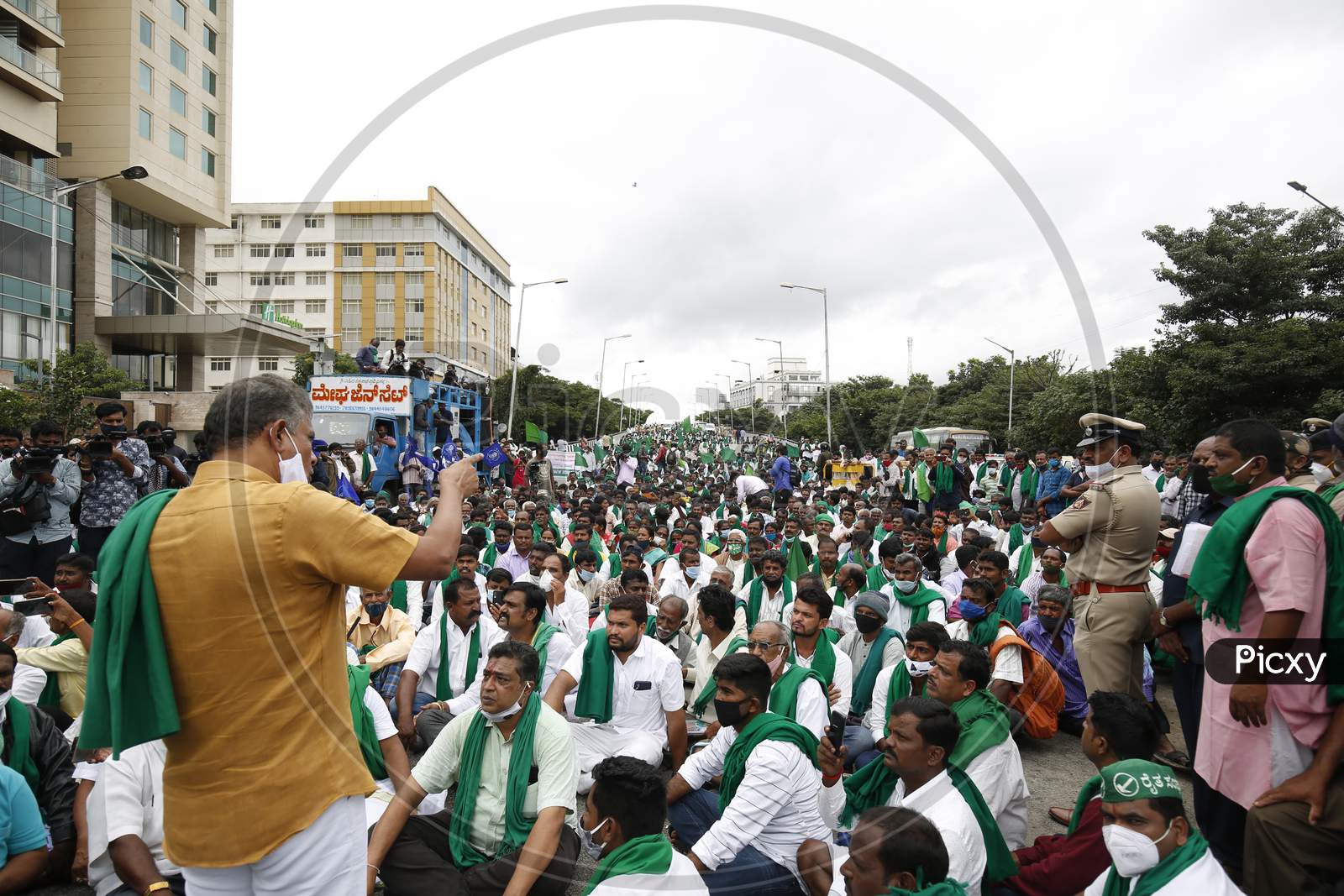 Farmers block a road as they listen to a party leader during a protest against the passage of two controversial farm bills by the country’s parliament in Bangalore, India.
