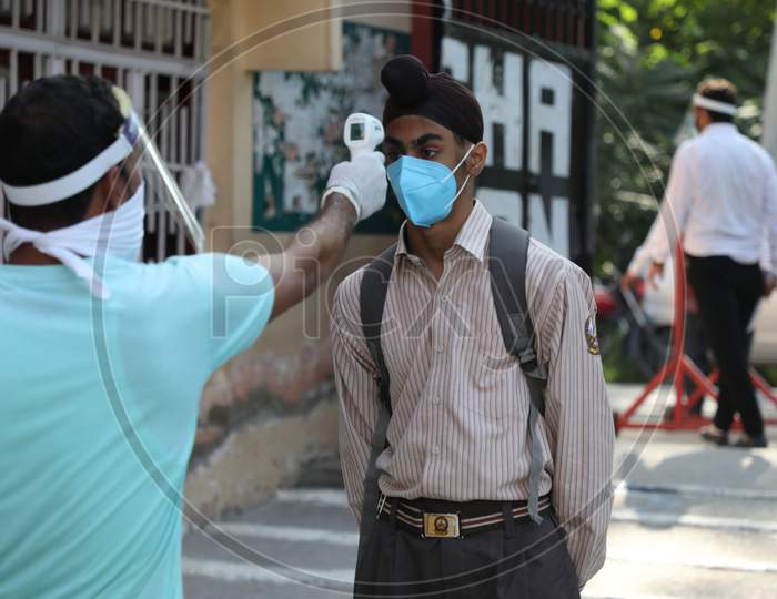 Students getting screened for fever at a school in Jammu on 21 September,2020. The schools across Jammu region partially reopened for 9th to 12th classes after six months closure due to the outbreak of Coronavirus pandemi .