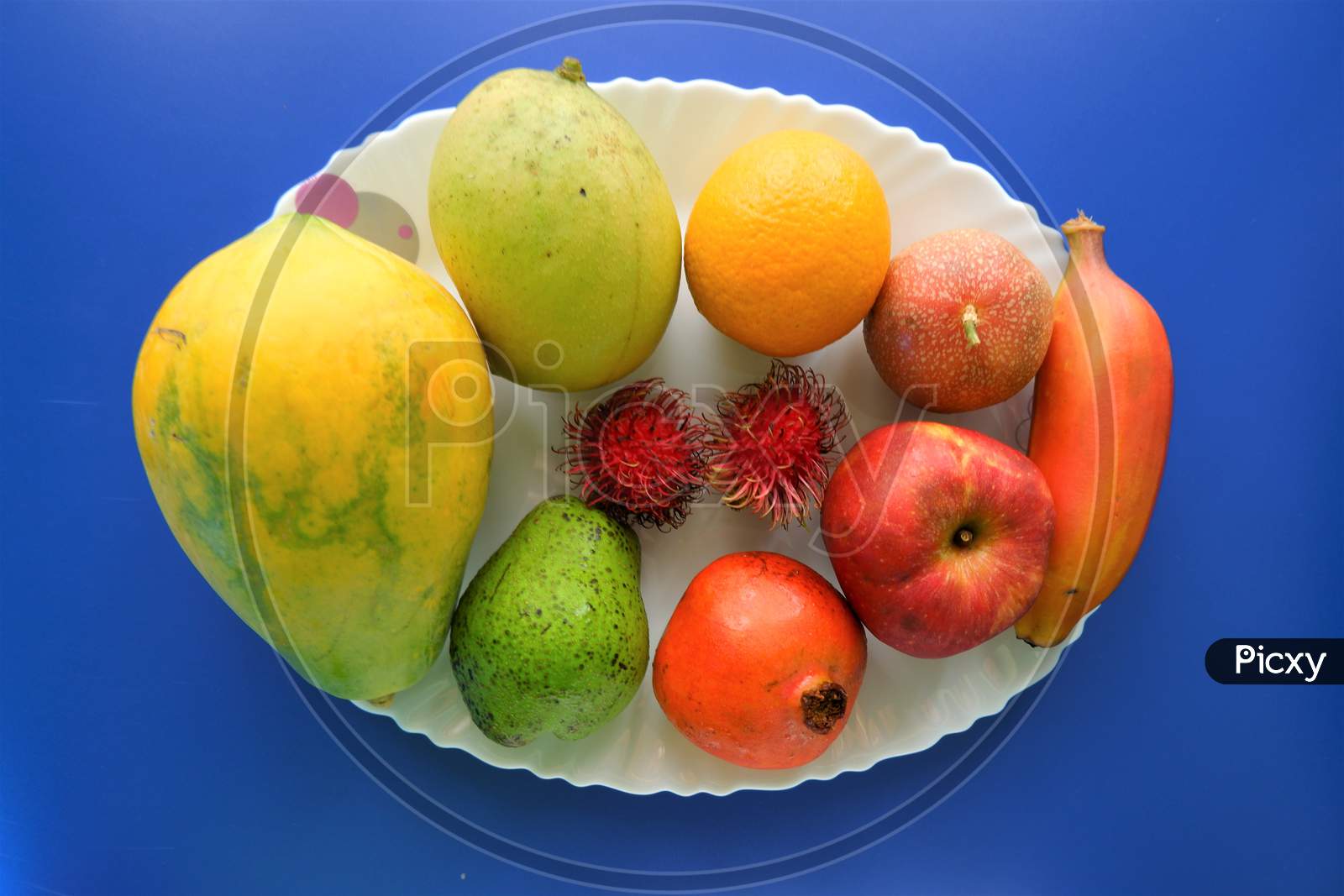 Healthy natural fruits on white plate ,top view,blue background