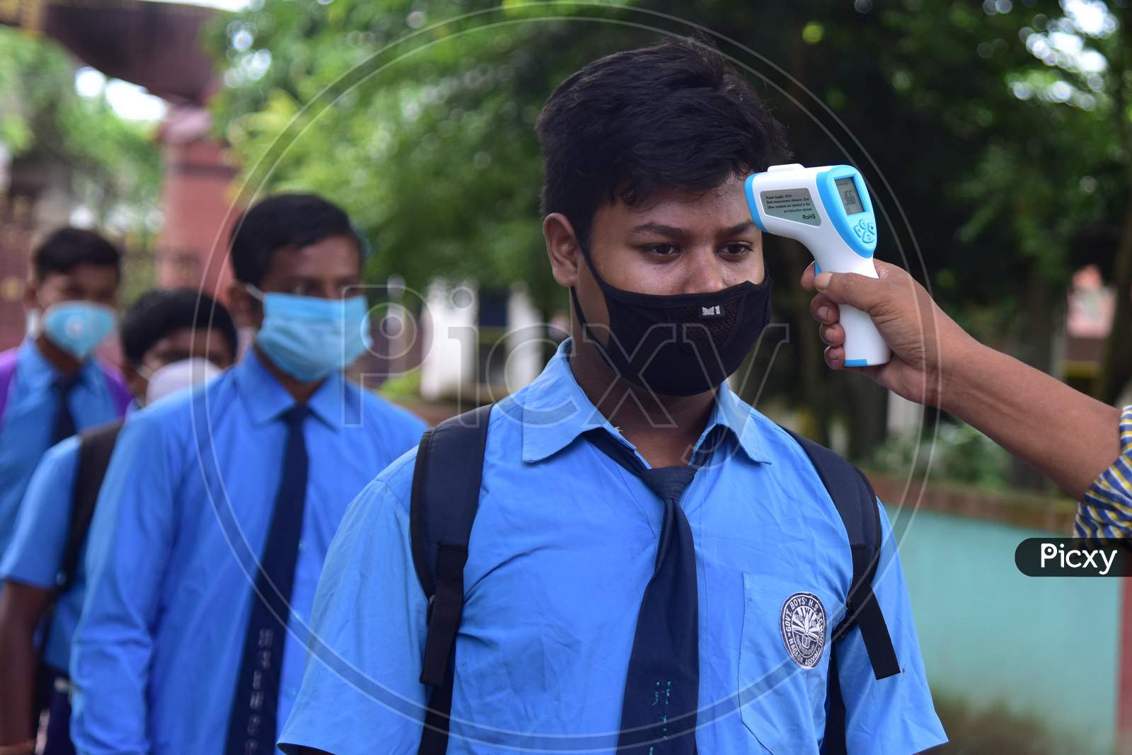 A student  gets his  body temperature check at the entrance gate of a school as schools reopened after more than 5-months closure due to the Covid-19 coronavirus pandemic in  Nagaon District of Assam on  sep 21,2020.