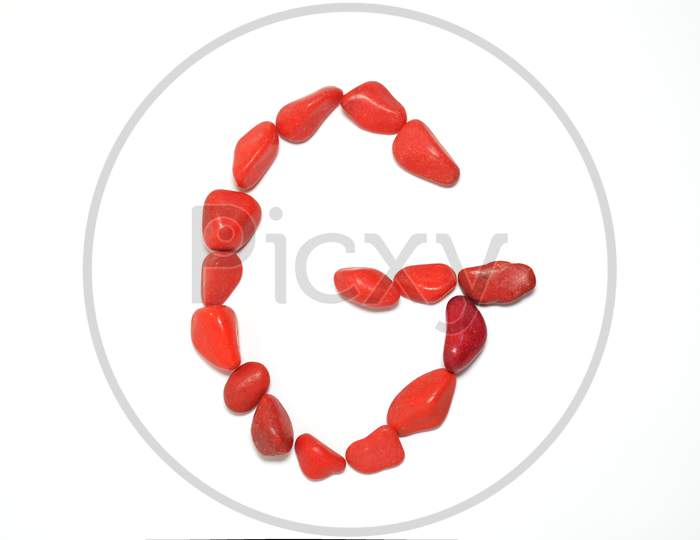 Alphabet In Red Pebbles On White Background