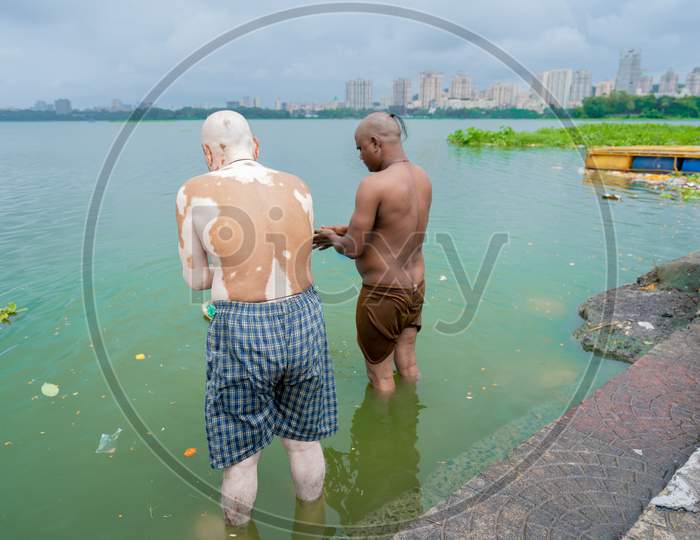 Two devotee performing pooja on the bank of powai lake.