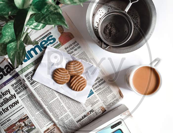 Morning chai with gooday and newspaper, flatlay photography