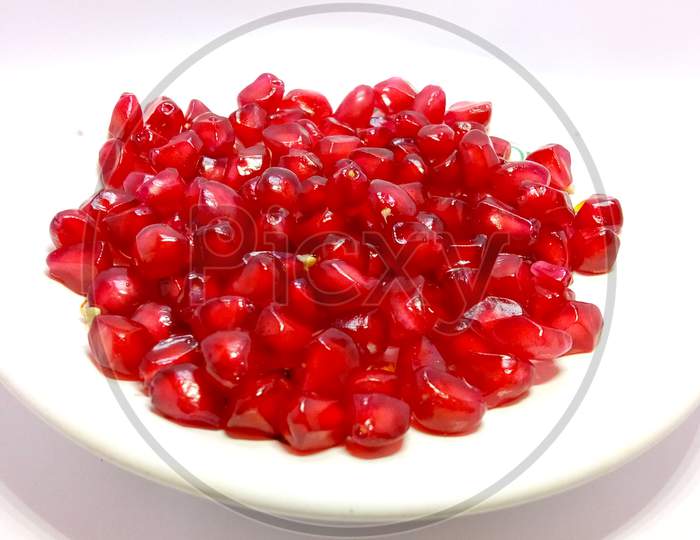 Red pomegranate seeds in isolated white background