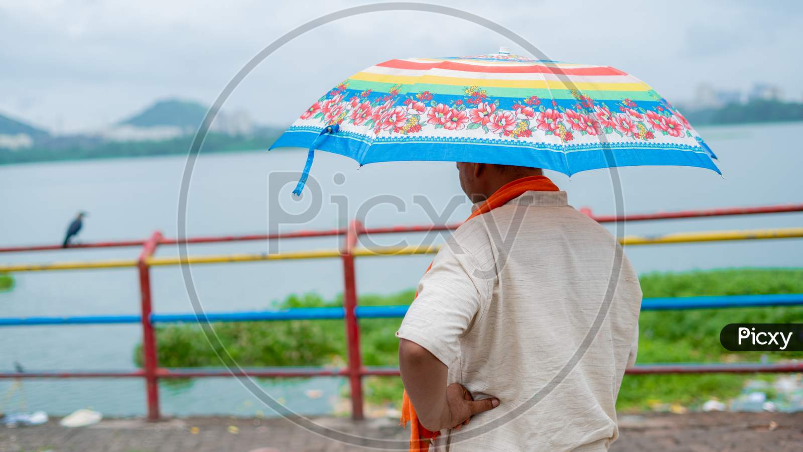 A hindu pandit with a colourful umbrella