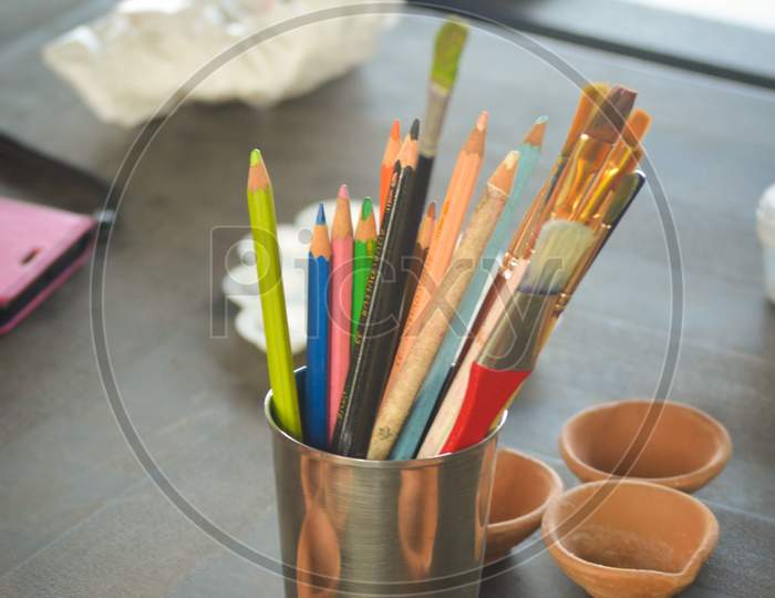 Color Pencils And Painting Brush In A Steel Glass