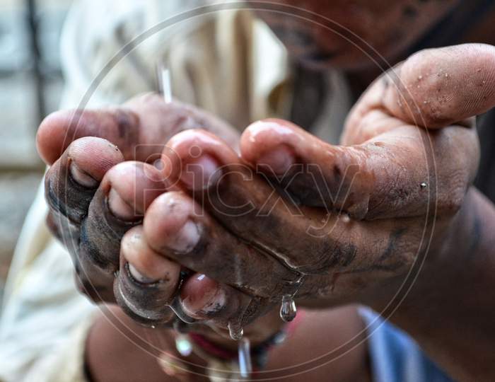 A Poor Beggar Is Taking Water In Hand To Drink