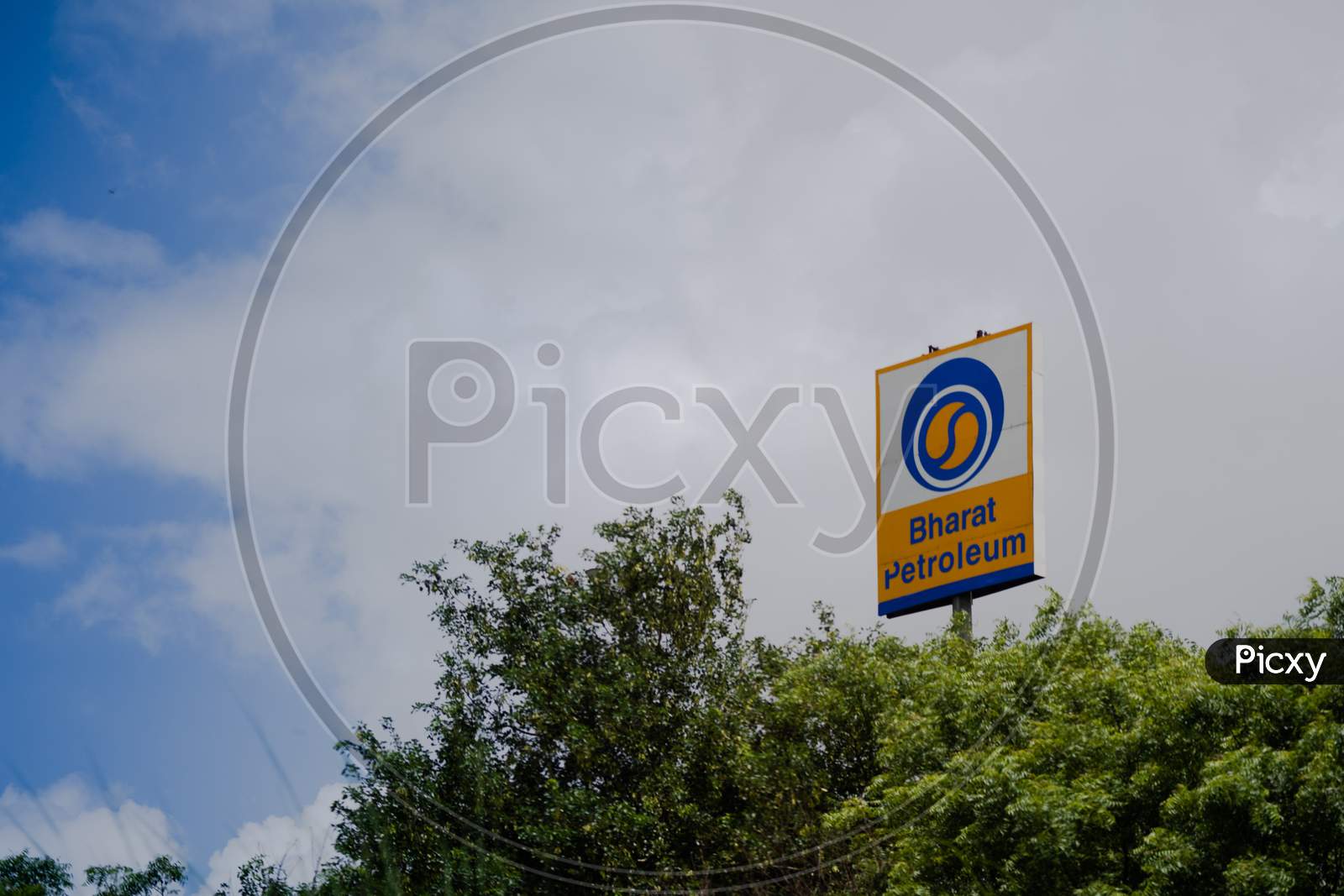 Signage Of Bharat Petroleum Standing From The Middle Of Trees Showing A Fuel Pump From One Of The Largest Public Sector Undertaking In The Petroleum Space