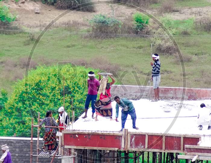 Construction Of Roof Of Building By Mixing Concrete At The Base And Using A Human Chain To Carry It To The Roof Where A Poor Poverty Stricken Labourer Pours It