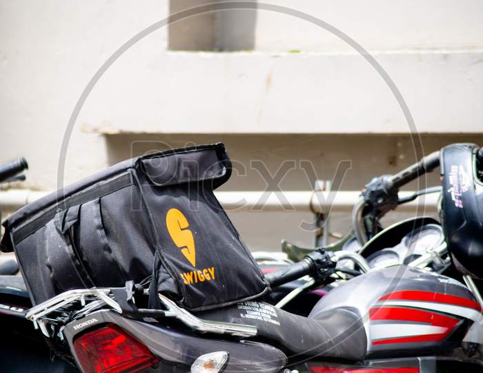Close Up Shot Of A Delivery Boy Bike Parked With A Swiggy Bag Mounted On It For Fresh Hot Food Delivery