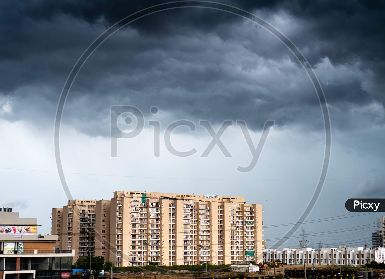 Gurgaon Delhi Cityscape With Monsoon Clouds Casting Shadows On High Rise Apartments And Buildings Showing Passage Of Time And Rapid Growth Of Real Estate And Infrastructure