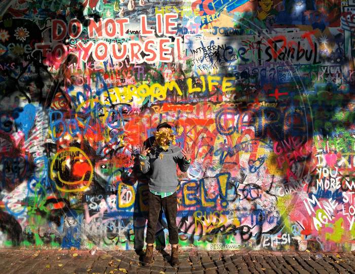 A happy man standing in front of a graffiti wall