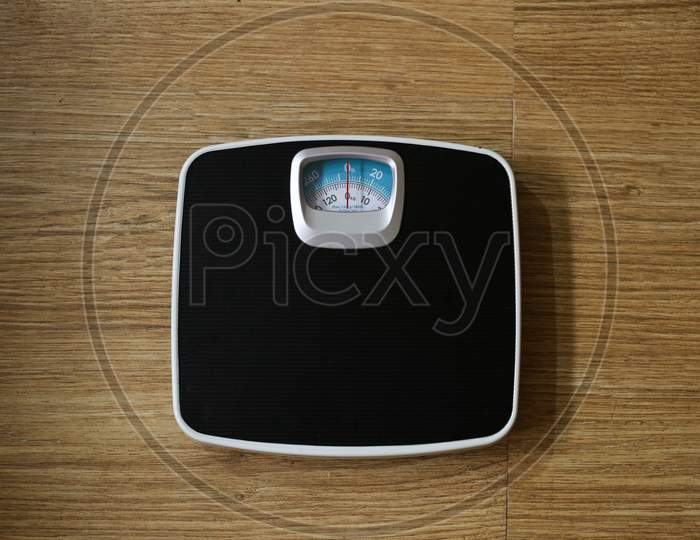 Black Color Weight Machine In A Wooden Background
