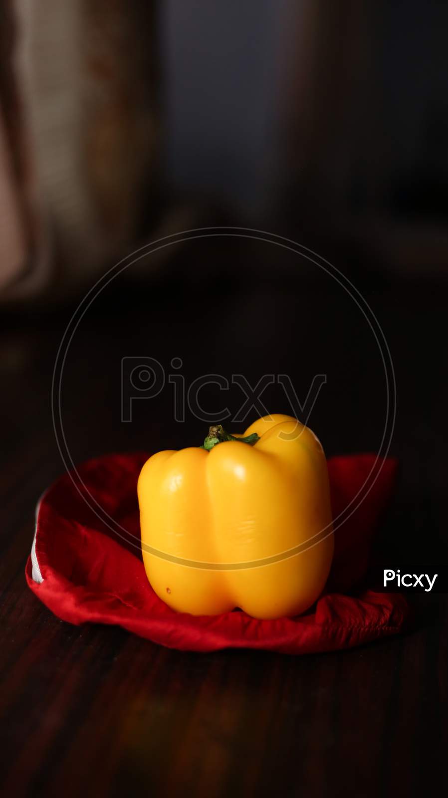 Closeup View Of Yellow Color Bell Pepper In Cooking Pan With Wooden Background