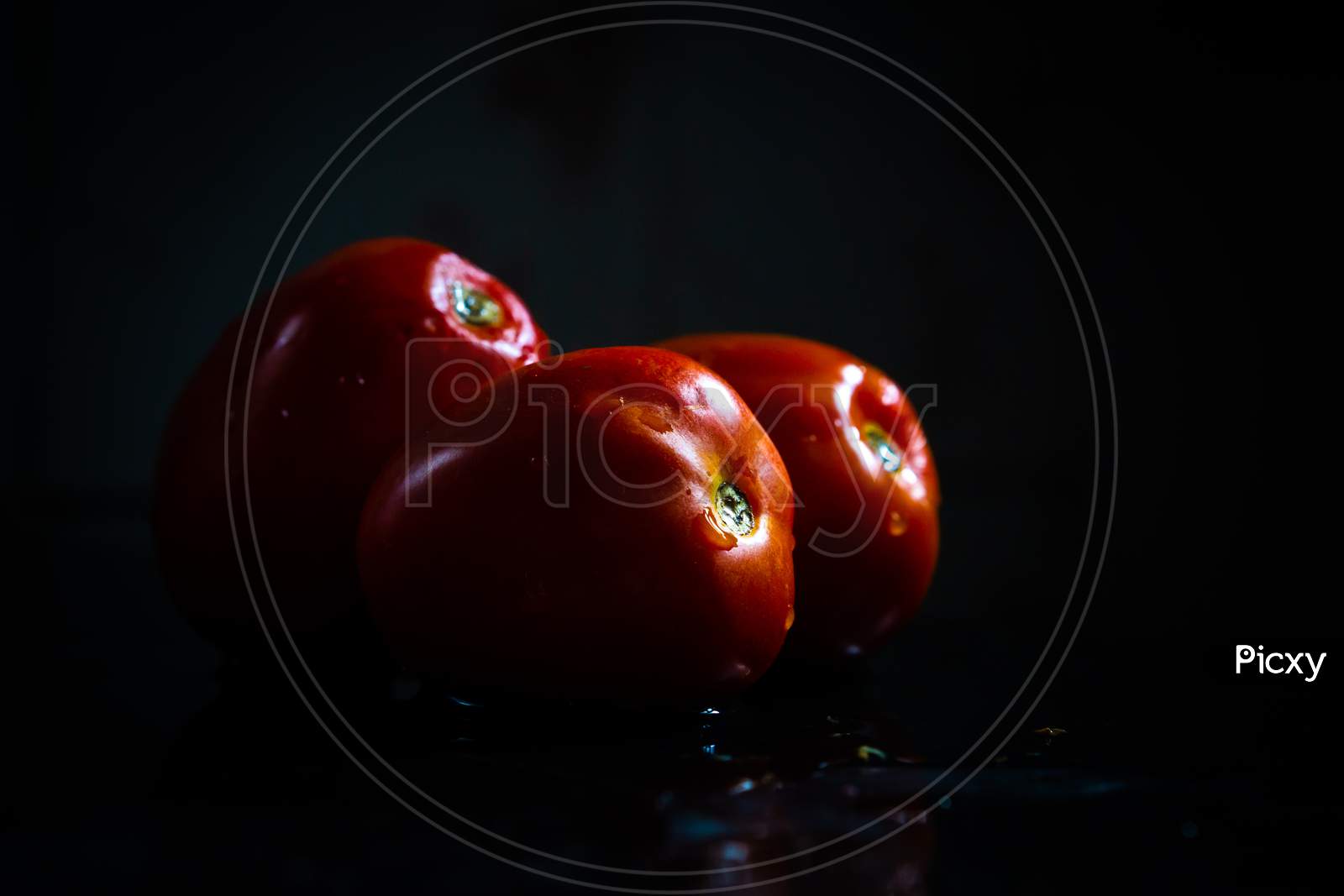 Juicy Tomato In A Group On A Dark Background