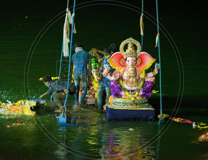 Group of people immersing the ganesh idols in hussain sagar ,hyderabad