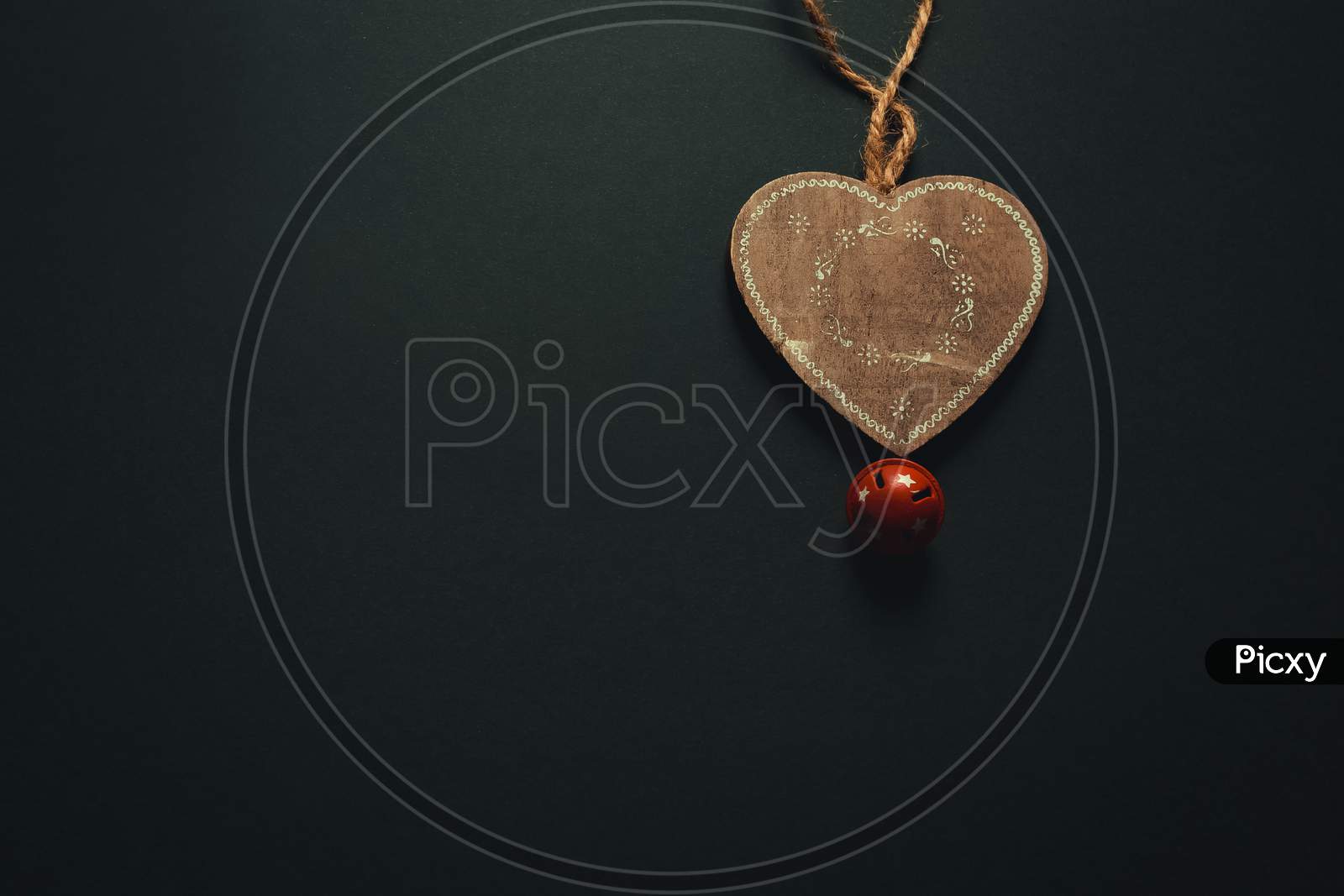 Christmas Flat Lay With A Wooden Heart And A Jingle Bell Over A Dark Background With Copy Space