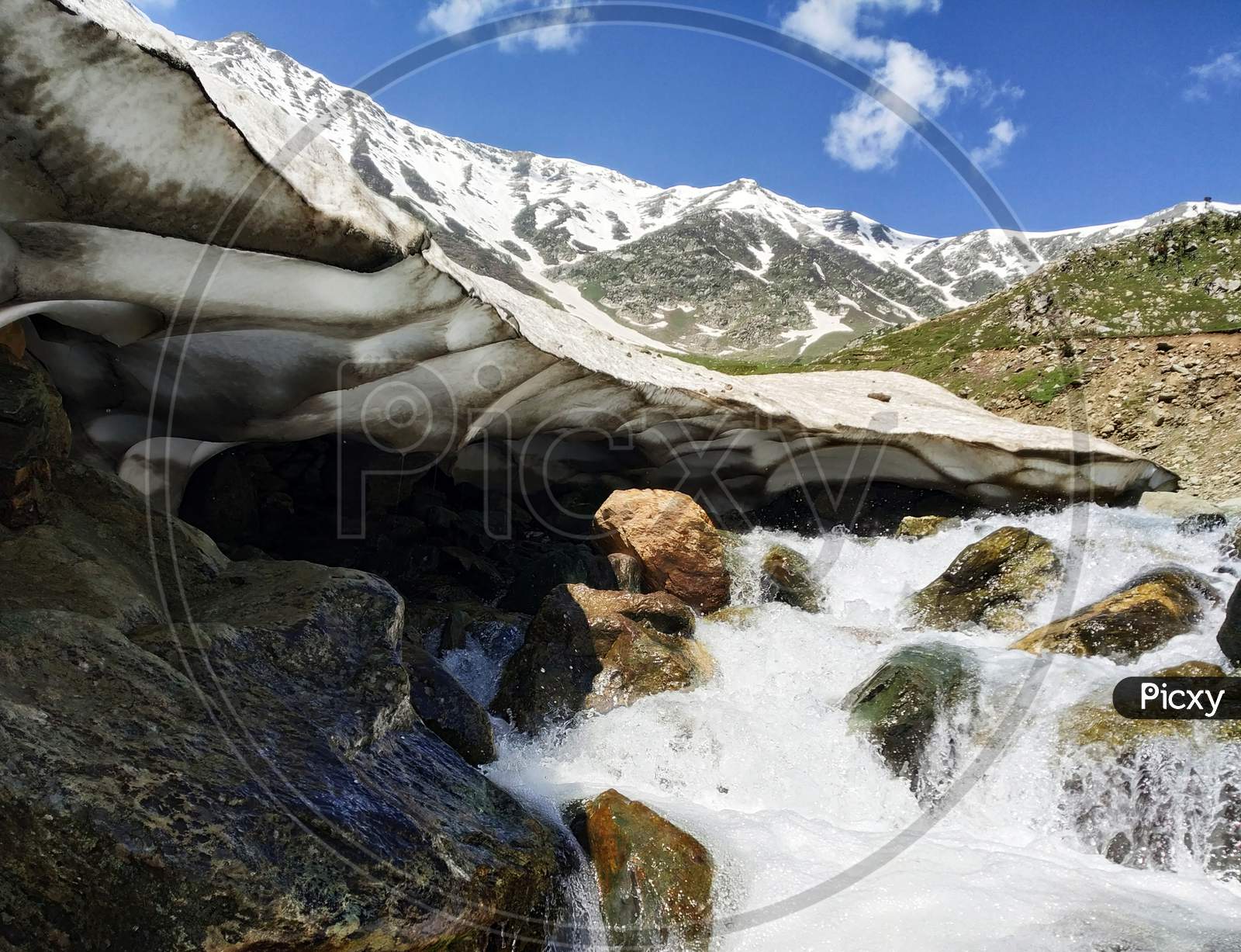 Landscape of snowcapped moutains and stream.