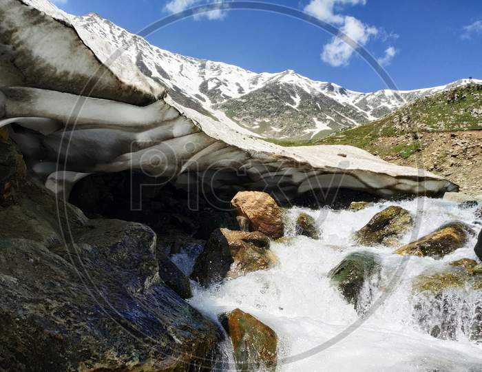 Landscape of snowcapped moutains and stream.