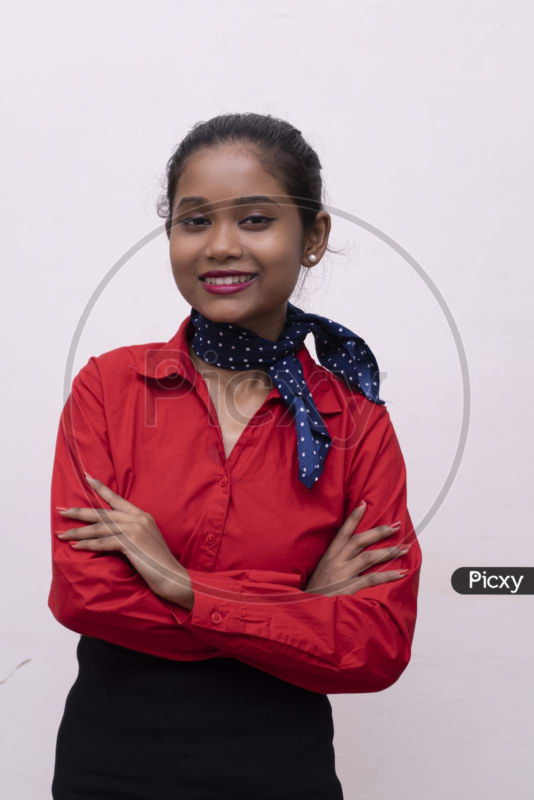 Young Charming Air Hostess In Red Dress With Blue Collar Posing In Front Of The Camera With White Background And Copy Space.