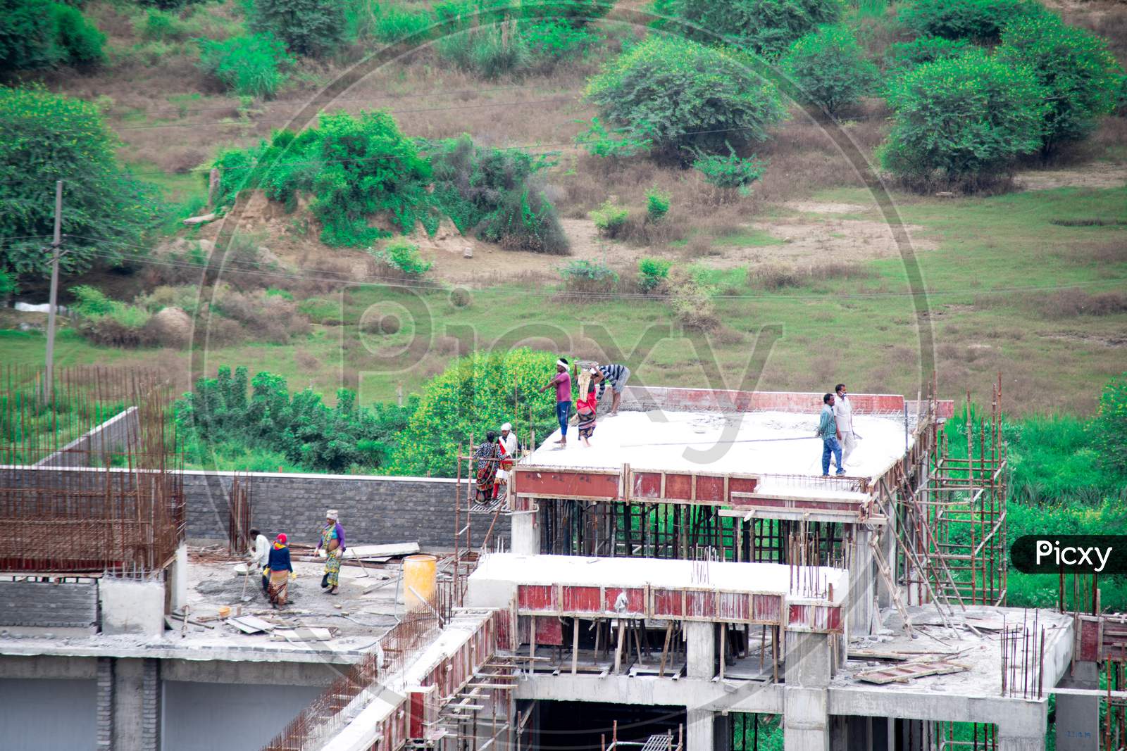 Construction Of Roof Of Building By Mixing Concrete At The Base And Using A Human Chain To Carry It To The Roof Where A Poor Poverty Stricken Labourer Pours It