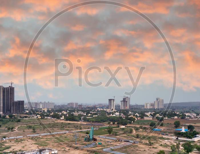Aerial Dusk Shot Of Buuldings With Warm Orange Lights Shining Out Of The Newly Constructed Homes Offices And Residences