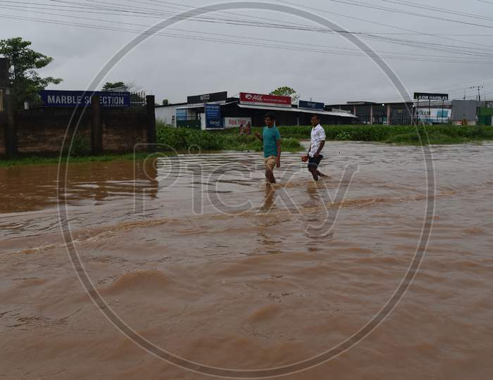 Commuters wade through a waterlogged street following heavy rainfall, at Boragaon in Guwahati on Tuesday, Sept. 22, 2020.
