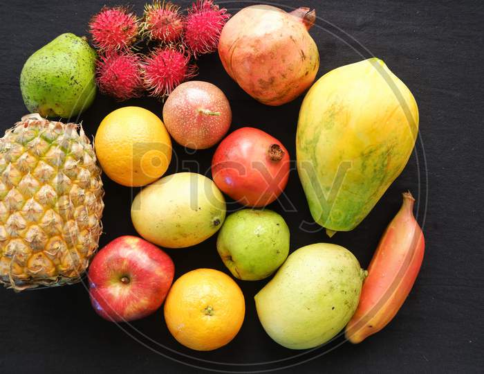 Healthy assorted natural fruits on black background ,top view,